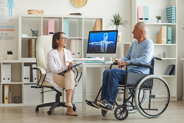 Ergothérapeute discutant avec un patient à mobilité réduite.